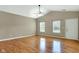 Spacious living room features vaulted ceilings, two windows with blinds, neutral paint, and hardwood flooring at 4295 Washington Blvd, Plainfield, IN 46168