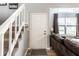 Bright entryway featuring stairs and a view into the living room with hardwood floors and a cozy couch at 4380 Dunsany Ct, Indianapolis, IN 46254