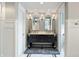 Bathroom showcasing a black vanity with double sinks, decorative mirrors, and stylish lighting at 4443 Mallard Pt, Columbus, IN 47201