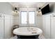 Bright bathroom featuring a freestanding tub, stylish lighting, and a television for relaxation at 4443 Mallard Pt, Columbus, IN 47201