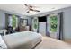 A bright, cozy bedroom with three large windows, carpet, and a ceiling fan at 4443 Mallard Pt, Columbus, IN 47201