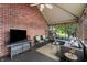 Comfortable screened in porch with tv, brick wall, ceiling fan, and views of the surrounding landscape at 4443 Mallard Pt, Columbus, IN 47201