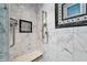 Close-up of a tiled shower with marble accents, bench seat and chrome showerhead at 4443 Mallard Pt, Columbus, IN 47201