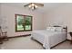 A bright bedroom with carpeted floors, ceiling fan, and a large window overlooking nature at 4670 N 600 E, Franklin, IN 46131