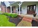 Charming front porch featuring classic rocking chairs, brick accents, lush landscaping, and a welcoming front door at 4670 N 600 E, Franklin, IN 46131