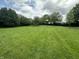 The beautiful backyard with trees and a basketball hoop is shown at 4673 S 400 W, New Palestine, IN 46163
