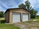 A modern two-car garage with a tan exterior and white doors, set on a well-maintained lawn at 4673 S 400 W, New Palestine, IN 46163