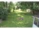 Lush backyard with mature trees, green grass, and a fire pit at 515 Hawthorne Ave, Anderson, IN 46011