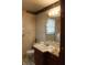 Bathroom with white vanity, sink, and mirror, showcasing patterned wallpaper and tile floors at 515 Hawthorne Ave, Anderson, IN 46011