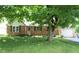 Charming brick home with a well-manicured lawn and mature tree offering ample shade at 515 Hawthorne Ave, Anderson, IN 46011