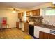 Outdated kitchen featuring wood cabinets, a laminate countertop, and patterned linoleum flooring at 515 Hawthorne Ave, Anderson, IN 46011