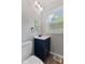 Bathroom with a dark vanity, modern faucet, and a window providing natural light at 5367 Penway St, Indianapolis, IN 46224