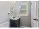 Bathroom featuring modern fixtures, a dark vanity with white countertop, and window at 5367 Penway St, Indianapolis, IN 46224