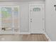 Bright entryway featuring a decorative glass door, window with blinds, and light gray walls at 5367 Penway St, Indianapolis, IN 46224