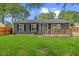 Charming gray home with a wooden porch, well-maintained lawn, and dark shutters on the windows at 5367 Penway St, Indianapolis, IN 46224