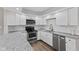 Modern kitchen featuring white cabinets, granite countertops, stainless steel appliances, and subway tile backsplash at 5367 Penway St, Indianapolis, IN 46224