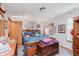 Bright bedroom features a queen size bed with patterned covers, wood furniture, and decorative art offering comfort and character at 5515 Gateridge Ln, Indianapolis, IN 46237