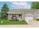 Charming brick home featuring a manicured lawn and inviting front porch with rocking chairs at 5515 Gateridge Ln, Indianapolis, IN 46237