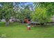Lush backyard featuring mature trees, a shed, a deck and ample space for outdoor activities and relaxation at 5614 Regency Dr, Indianapolis, IN 46224