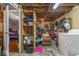 An unfinished basement features open rafters, exposed pipes, and a washing machine at 5614 Regency Dr, Indianapolis, IN 46224