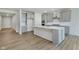 Spacious kitchen with gray cabinets, stainless steel appliances, a center island, and wood floors at 5673 Stetson Dr, Whitestown, IN 46052