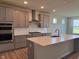 Bright kitchen boasts modern gray cabinets, stainless steel appliances, and a large center island with quartz countertop at 5673 Stetson Dr, Whitestown, IN 46052