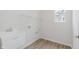 Bright laundry room featuring white walls, wood-look floors, a utility sink, and shelving at 5673 Stetson Dr, Whitestown, IN 46052