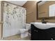 Tan bathroom with a floral shower curtain and dark vanity at 5857 Stone Pine Trl, Carmel, IN 46033
