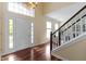 Bright foyer with hardwood floors, staircase, and a stylish light fixture at 5857 Stone Pine Trl, Carmel, IN 46033