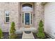 Inviting front entrance with a decorative glass door, sidelights and brick surround at 5857 Stone Pine Trl, Carmel, IN 46033