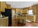 Well-lit kitchen with wood floors, an island with seating, and stainless steel appliances at 5857 Stone Pine Trl, Carmel, IN 46033