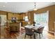 Bright kitchen open to a dining area, featuring stainless steel appliances and a view of the outdoor scenery at 5857 Stone Pine Trl, Carmel, IN 46033
