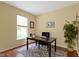Home office with a wooden desk, a blue chair, and natural light from a window at 5857 Stone Pine Trl, Carmel, IN 46033