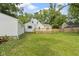 View of the backyard, back deck, and white home with the garage on the left at 6833 Evanston Ave, Indianapolis, IN 46220