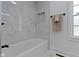 Crisp, white tiled shower and tub combination, complimented by marble flooring, in a modern bathroom at 6833 Evanston Ave, Indianapolis, IN 46220