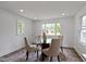 Bright dining room with modern table set, recessed lighting, and large windows showcasing the outdoor view at 6833 Evanston Ave, Indianapolis, IN 46220