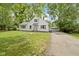 White two-story home featuring a detached garage, a well-manicured lawn, and an inviting entrance at 6833 Evanston Ave, Indianapolis, IN 46220