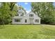 Charming white two-story home with a well-maintained front yard and surrounded by mature trees at 6833 Evanston Ave, Indianapolis, IN 46220