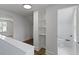 Bright hallway featuring a built-in bookshelf, hardwood flooring, and a full bathroom at 6833 Evanston Ave, Indianapolis, IN 46220
