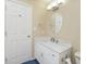 Bright bathroom featuring a modern vanity with marble countertop, a sink, and a circular mirror at 6920 Wesley Ct, Indianapolis, IN 46220