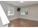 Minimalist bedroom with two windows providing natural light, complemented by neutral walls and dark floors at 6920 Wesley Ct, Indianapolis, IN 46220