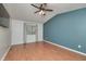 Bright bedroom featuring wood floors, ceiling fan, a window, and an accent wall at 6920 Wesley Ct, Indianapolis, IN 46220