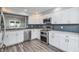 Updated kitchen features stainless steel appliances, bright white cabinetry, and subway tile backsplash at 6920 Wesley Ct, Indianapolis, IN 46220