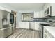 Well-lit kitchen featuring stainless steel appliances, white cabinets, and a modern backsplash at 6920 Wesley Ct, Indianapolis, IN 46220