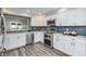 Modern kitchen with stainless steel appliances, white cabinetry, and stylish backsplash at 6920 Wesley Ct, Indianapolis, IN 46220