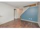 Simple room with hardwood floors, stairs and a muted blue accent wall at 6920 Wesley Ct, Indianapolis, IN 46220