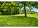 Expansive grassy backyard with mature trees creating a serene and private outdoor space at 7533 Deerfield Dr, Greenfield, IN 46140
