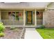 Charming front porch adorned with hanging flower baskets and decorative details, creating a warm and inviting entrance at 7533 Deerfield Dr, Greenfield, IN 46140