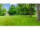 Lush front yard with mature trees adding beauty and curb appeal to this well-maintained property at 7533 Deerfield Dr, Greenfield, IN 46140