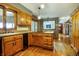 Open kitchen area with wood cabinets, hardwood floor, black dishwasher, and a sink overlooking the yard at 7533 Deerfield Dr, Greenfield, IN 46140
